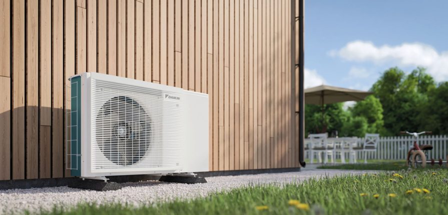 Unità di climatizzazione esterna installata accanto a una casa moderna in legno.